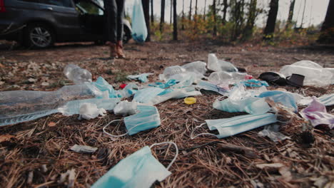 persona tira basura en el bosque