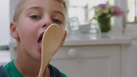 glücklicher kleiner junge schmeckt leckeren schokoladenpudding mit einem löffel und genießt hausgemachte leckereien in der küche