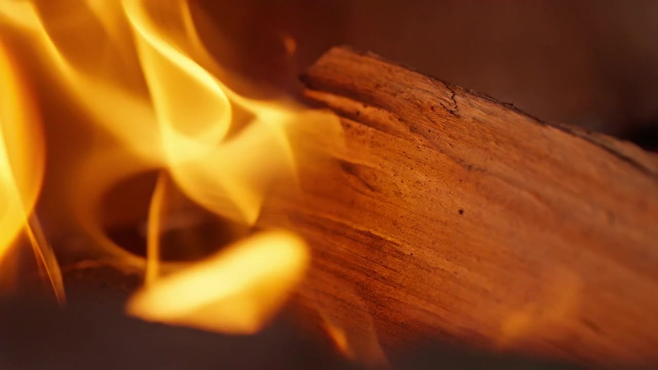 Nærbillede af brændende træ med klare orange flammer