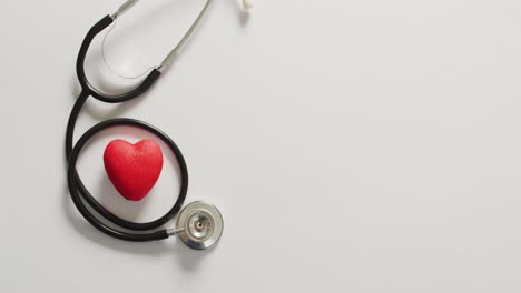 Video-of-close-up-of-stethoscope-with-heart-on-blue-background