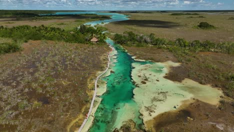 Luftaufnahme-über-Menschen,-Die-In-Den-Stromschnellen-Von-Bacalar-Schwimmen,-Im-Sonnigen-Mexiko---Rückwärts,-Geneigt,-Drohnenaufnahme