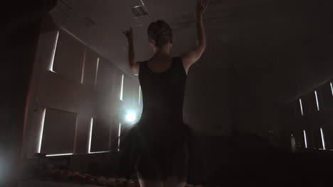 movimiento lento: prima ballet en el escenario ensayando la actuación en la luz oscura de la contra. las luces de la sala