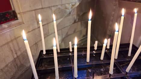 close-up view with a smooth panning movement about a few candles in l'abbaye-aux-hommes, caen, france