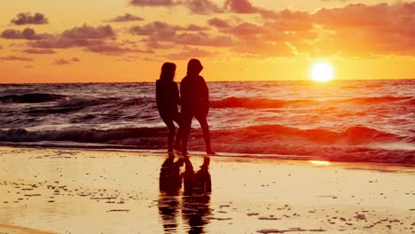 dos chicas jóvenes viendo la puesta de sol en la playa