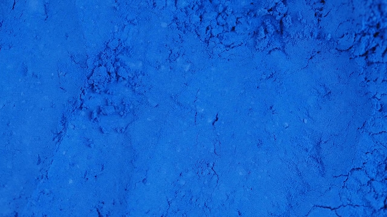Primer plano de polvo de pigmento azul vibrante.