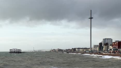 wide angle establishing shot i360 and west pier in brighton, england