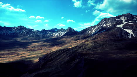 Ladera-Cubierta-De-Hierba-Seca-Contra-El-Telón-De-Fondo-De-Las-Montañas-Nevadas