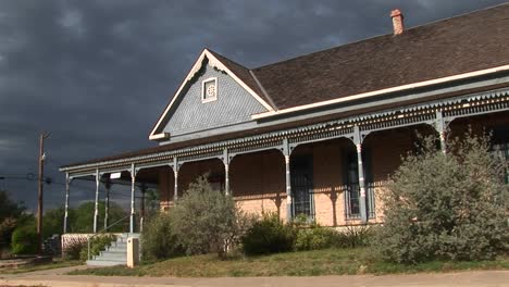 mediumshot of a ranch house as storm clouds gather behind it