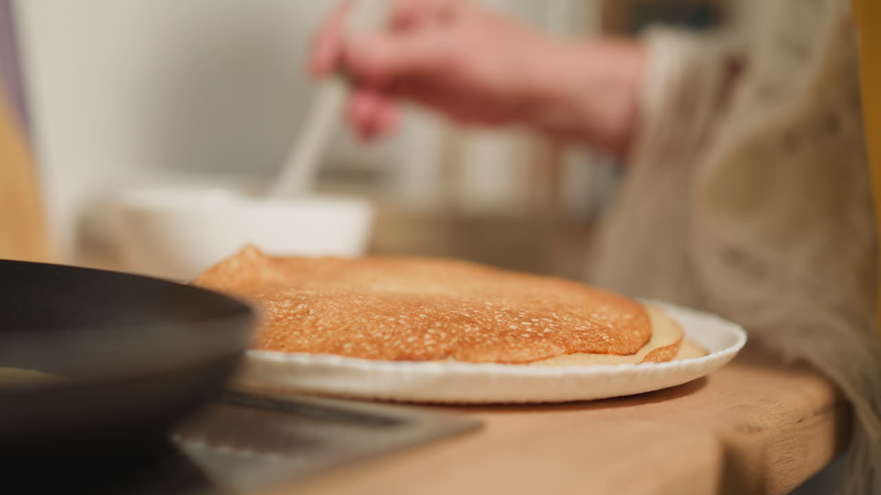 여성의 손은 실리콘 브러시로 페이스트리에 퍼져 있습니다.