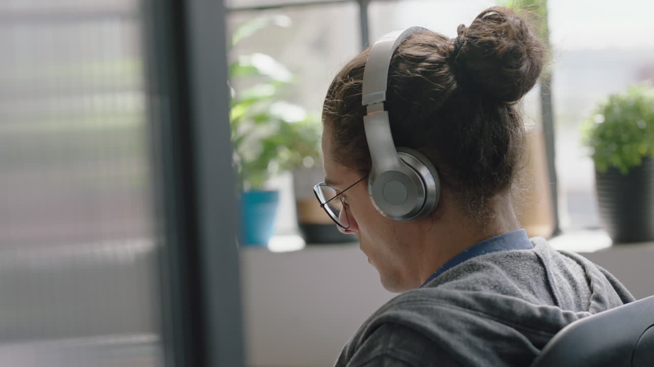 giovane uomo d'affari caucasico che usa il computer digitare navigare online ricerca focalizzata imprenditore che lavora in un ufficio di startup brainstorming ascoltare musica