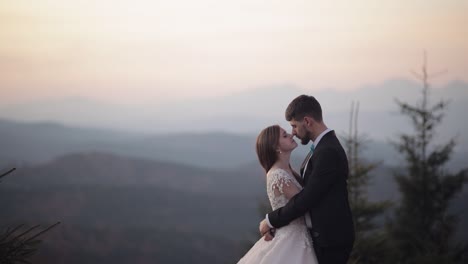 Recién-Casados.-Novio-Caucásico-Con-Novia-En-La-Ladera-De-La-Montaña.-Pareja-De-Novios.-Felices