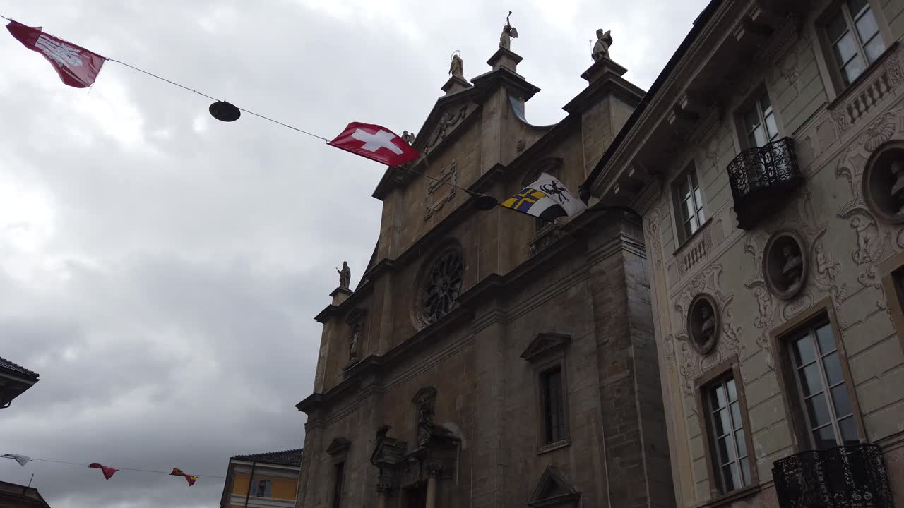 bandera suiza ondeando en la catedral de bellinzona, iglesia de punto de referencia histórico en ticino
