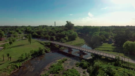 Aéreo---Río-Y-Puente-En-La-Pequeña-Ciudad-De-Mercedes,-Argentina,-Tiro-De-Bajada-Hacia-Adelante