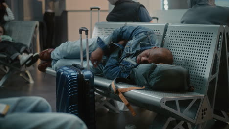 man sleeping in airport lounge