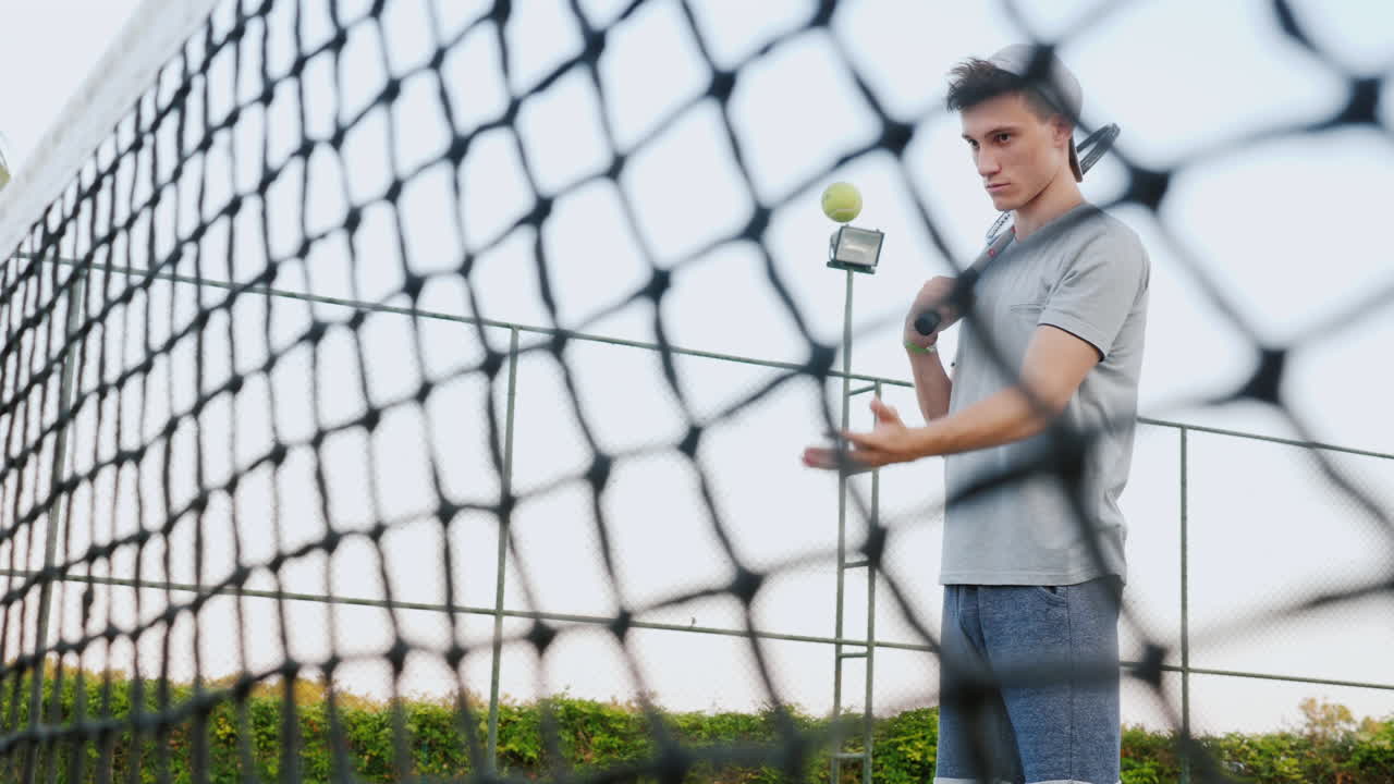 un hombre antes de un juego de tenis sintoniza el juego lanza la pelota