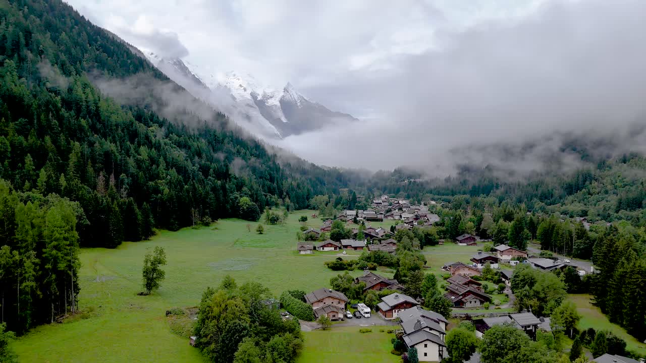 Video aereo 4K ad alta risoluzione realizzato con drone della splendida città di Argentière, in Francia, parte integrante del famoso TMB (Tour du Mont Blanc), durante una nebbiosa e tranquilla mattinata nel mese di settembre.