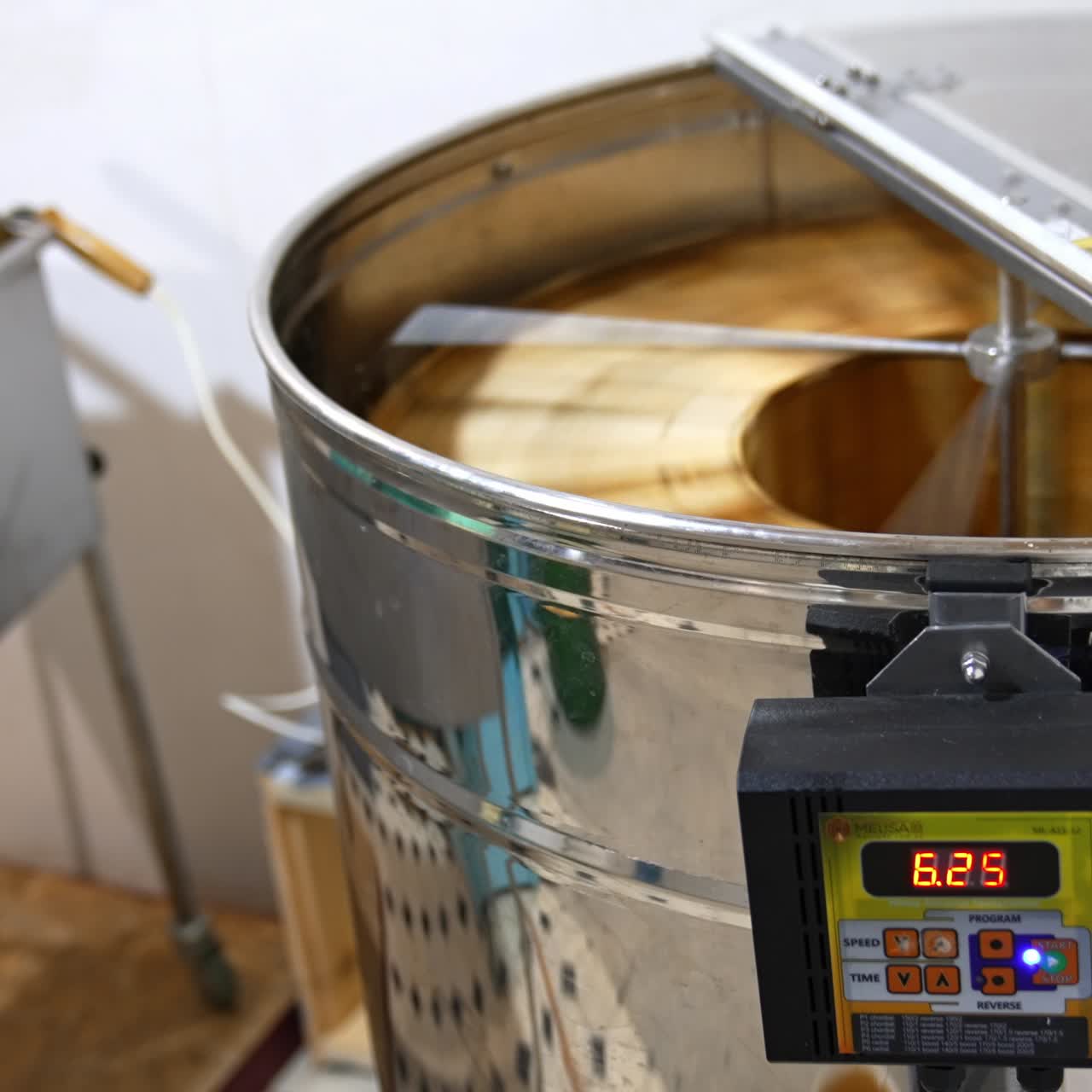 Metal electronic centrifuge device rotating the wooden frames with honeycombs. Extraction of organic honey at apiary