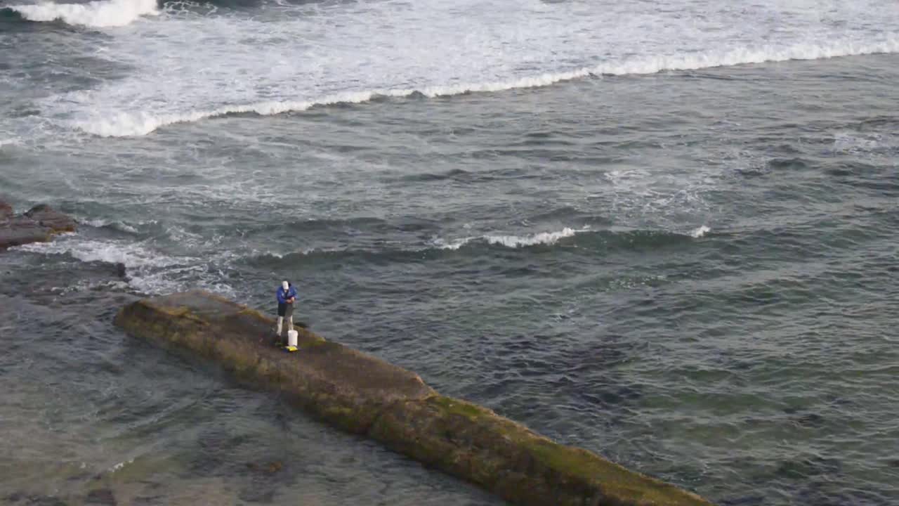 Man rock fishing at Bar Beach-Merewether Beach, NSW, Australia