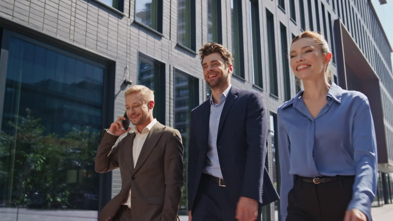 hombres de negocios pisando la calle una mañana soleada. felices colegas caminando por la ciudad