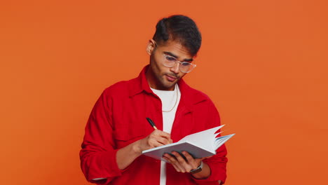 thoughtful indian man making notes writing down thoughts with pen into notepad notebook good idea