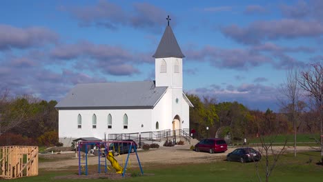 Churchgoers-arrive-at-a-pretty-white-church-in-the-countryside-1