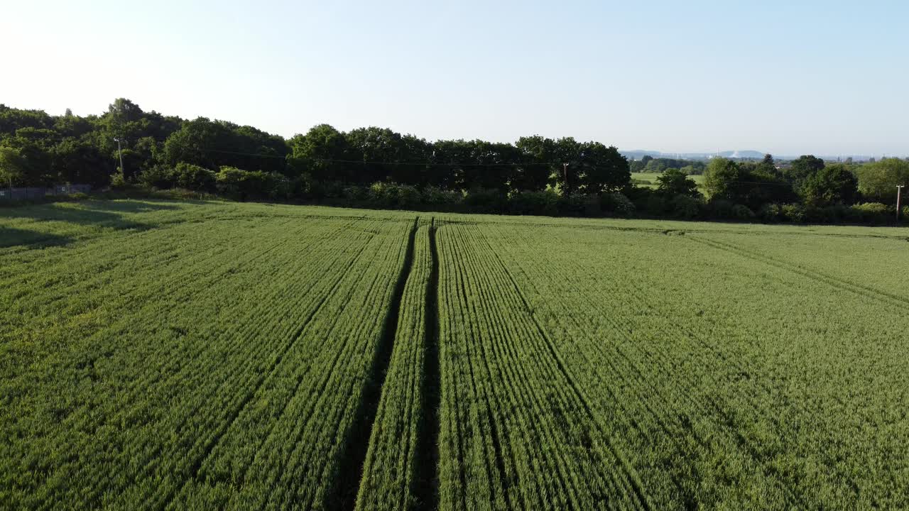 Ascending aerial shot of a green beautiful field in the heart of cronton village, united kingdom with view of the beautiful nature with trees and blue sky on sunny day