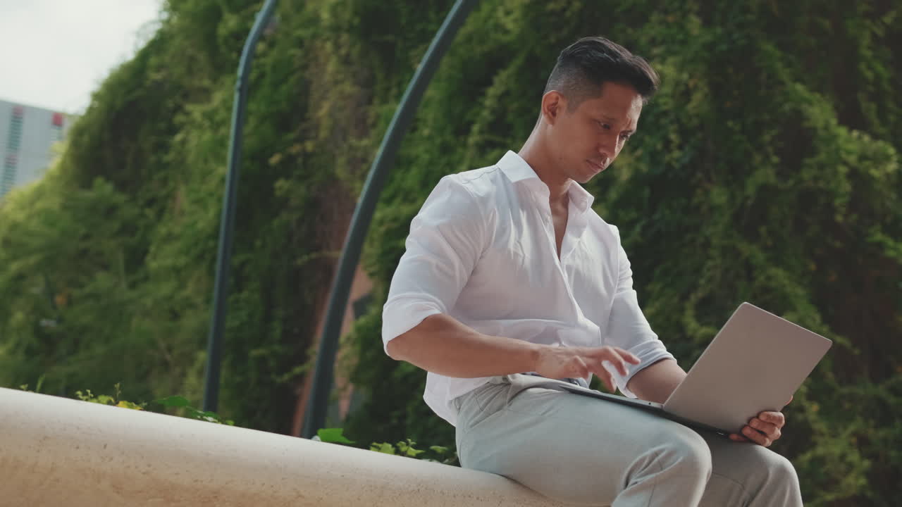 공원에서 노트북으로 일하는 남자