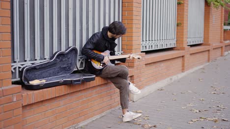 guy playing on the giutar on the street