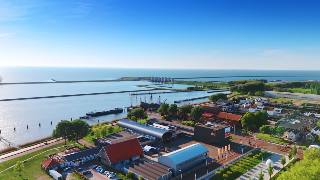 Approaching a reconstruction of the ship Batavia at Museum Batavialand. Drone flight above the waterfront of the lake in Lelystad, the Netherlands.