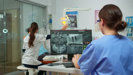 nurse analysing digital x-ray sitting in front of pc