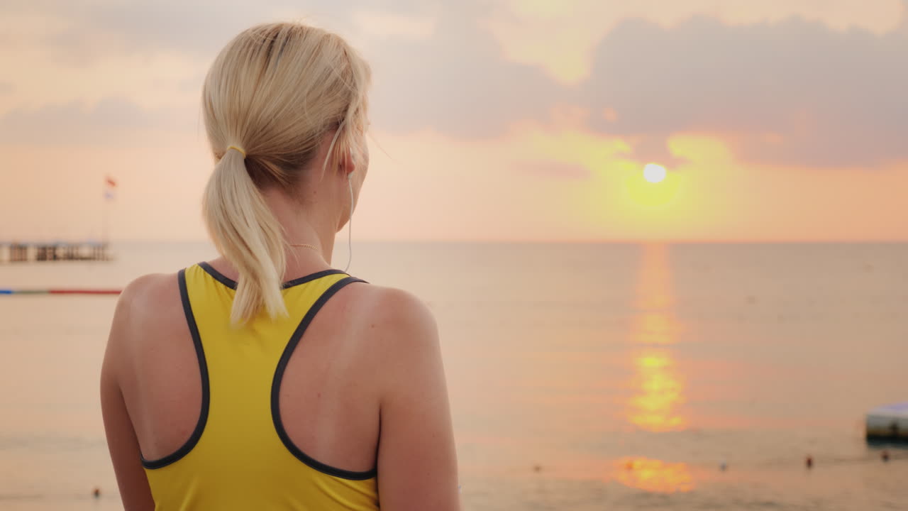 mujer activa bebiendo agua limpia después de practicar deportes en el fondo del mar donde el sol ri