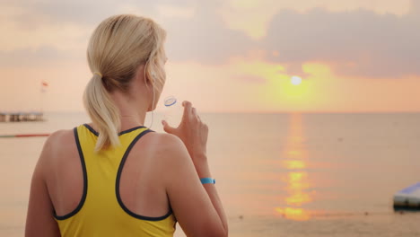 mujer activa bebiendo agua limpia después de practicar deportes en el fondo del mar donde el sol ri