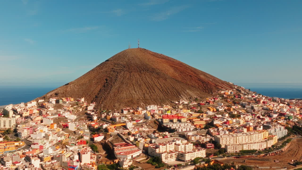 Aerial: top of the mountain during the day and cityscape in Gran Canaria, Spain, orbit drone shot