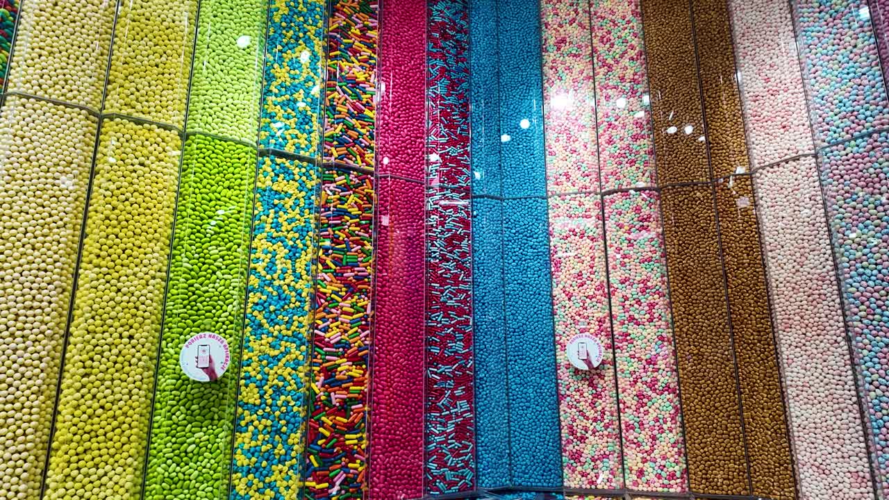 Colorful candy display in a candy shop with assorted sweets in vertical containers