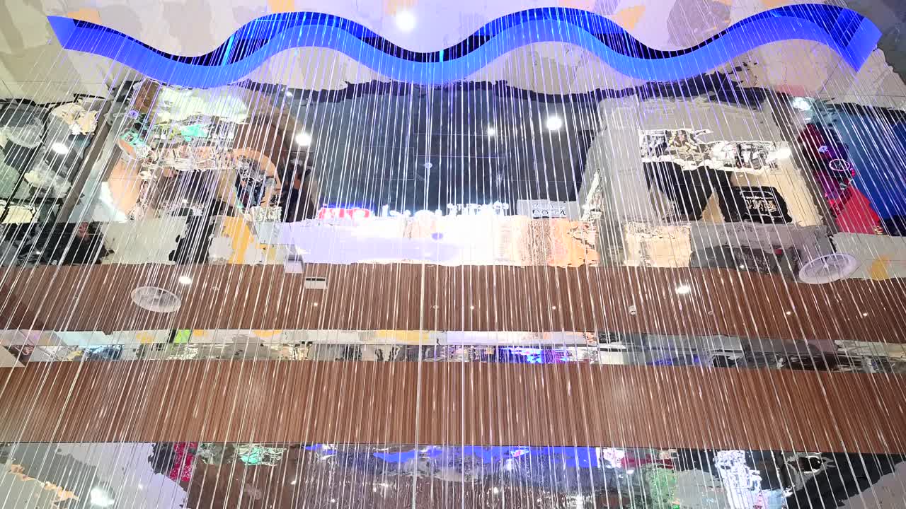 View of a hanging string light curtain installation beneath a wave shaped ceiling in Nicosia Mall, Cyprus
