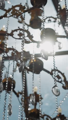 gorgeous vintage luster with chains and crystal decor at window back sunlight closeup. classic style interior element of home. elegant electric equipment
