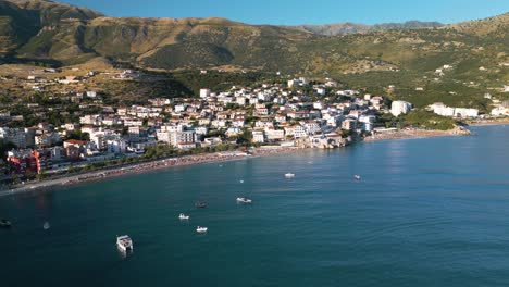 Cinematic-Establishing-Shot-Above-Albanian-Riviera-Beach-Town-on-Typical-Summer-Day