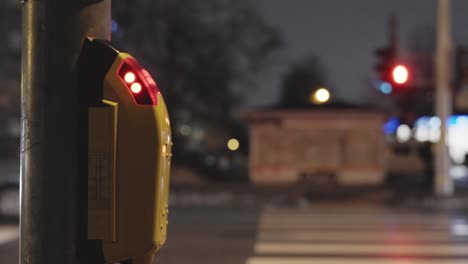 Pressing-the-button-for-regulated-crosswalk-in-a-city,-closeup-on-hand