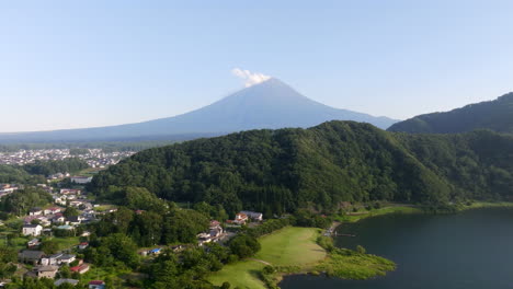 aerial view of forested hills with mount fuji in the background, summer in japan