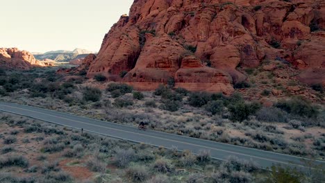 cyclist pedals alone on road across snow canyon in utah