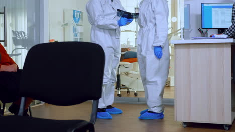médicos de ortodoncia con escudo facial y traje de ppe discutiendo