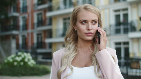 closeup businesswoman walking in suit. businesswoman talking phone outdoors