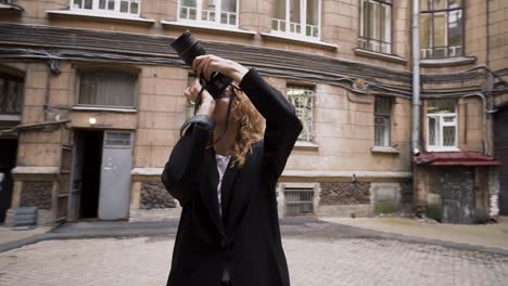 woman taking pictures in a city street