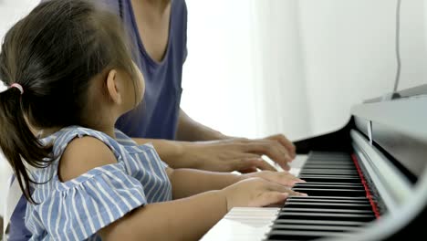 4k : slow motion of asian girl playing piano with her mother