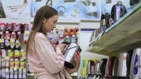 mujer comprando un hervidor eléctrico en una tienda de electrodomésticos