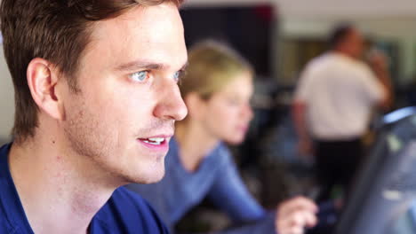 close up of man exercising on cycling machine in gym