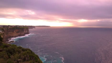 Perfect-golden-hour-sunrise-drone-shot-of-ocean-and-cliff-with-velvet-sky-early-in-a-beautiful-morning-near-a-beach