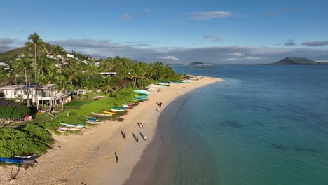 60fps-slow-mo-lanikai-beach-at-sunrise-morning-with-lots-of-people-on-beach-and-blue-ocean-and-homes-palm-trees-canoes-and-mountains-on-oahu-hawaii