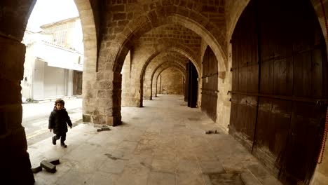 outside arched  vault of buyuk han child enters in frame