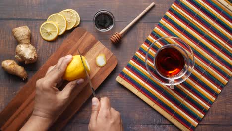 preparing a healthy drink with lemon, ginger, and honey